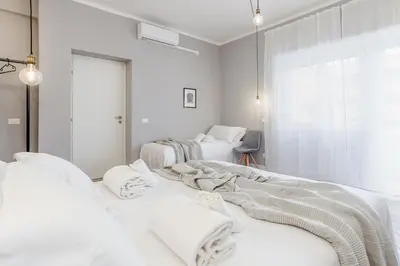 a white room with three beds with towels on them at Otium Fornaci San Pietro Vaticano Castel Sant'Angelo in Rome