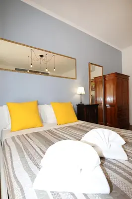 a bedroom with a large bed with yellow pillows at Unique luxury apartment and rooms in Rome