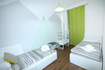 a bedroom with two beds and a green curtain at Unique luxury apartment and rooms in Rome