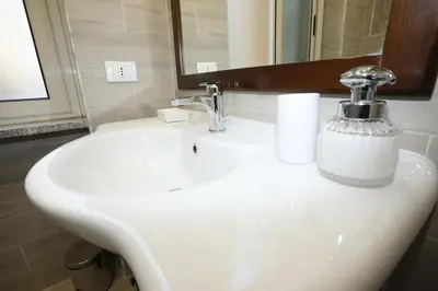 a bathroom with a white sink and a mirror at Unique luxury apartment and rooms in Rome