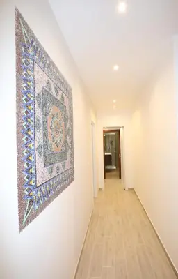 a hallway with a rug on the wall and a painting on the wall at Unique luxury apartment and rooms in Rome