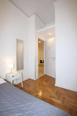 a white room with a bed and a table at Unique luxury apartment and rooms in Rome
