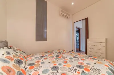 a bedroom with a bed with a comforter on it at GuestHost - Colosseo & San Clemente Cozy Flat in Rome