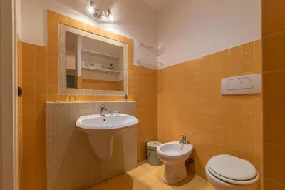 a bathroom with a sink and a toilet and a mirror at GuestHost - Colosseo & San Clemente Cozy Flat in Rome