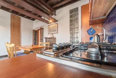 a kitchen with a stove top oven next to a table at GuestHost - Colosseo & San Clemente Cozy Flat in Rome