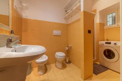 a bathroom with a sink and a washing machine at GuestHost - Colosseo & San Clemente Cozy Flat in Rome