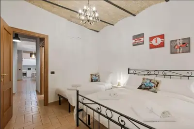 a bedroom with two beds and a chandelier at Roma Colosseum Apartment in Rome