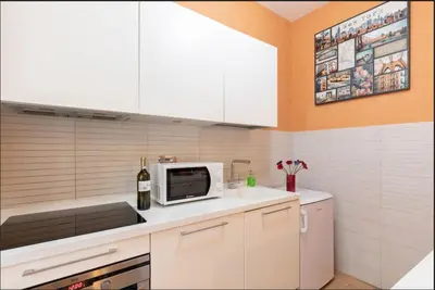 a kitchen with white cabinets and a microwave at Roma Colosseum Apartment in Rome