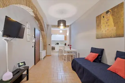 a bedroom with a bed and a living room at Roma Colosseum Apartment in Rome