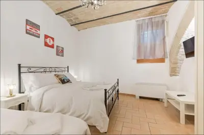 a bedroom with two beds and a television in it at Roma Colosseum Apartment in Rome