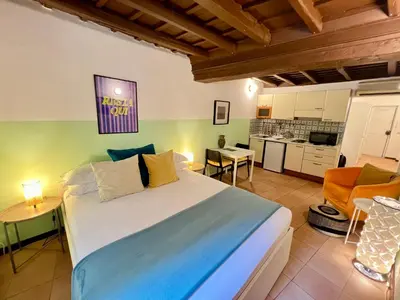 a bedroom with a large bed and a kitchen at Charming Campo de' Fiori in Rome