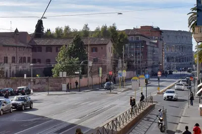 a busy city street with cars and people crossing a bridge at Rome Labicana Apartment in Rome