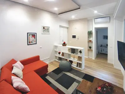 a living room with an orange couch and a tv at Rome Labicana Apartment in Rome