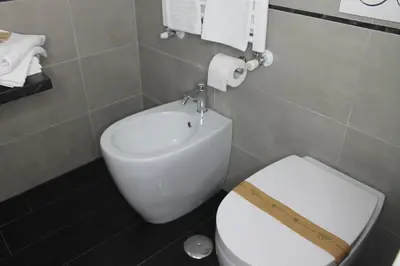 a bathroom with a white toilet and a sink at Roma suite Piramide in Rome