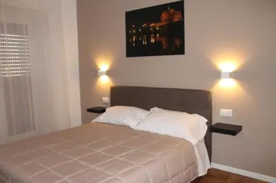 a bedroom with a bed with two lights on the wall at Roma suite Piramide in Rome