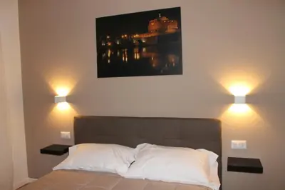 a bedroom with a bed with two lights above it at Roma suite Piramide in Rome