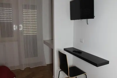a room with a desk and a television on a wall at Roma suite Piramide in Rome