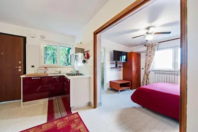 a bedroom with a bed and a kitchen with a sink at Mons Aureus Resort in Rome