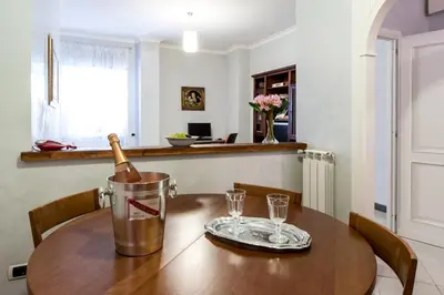 a dining room table with a bottle of wine in a bucket at Mons Aureus Resort in Rome