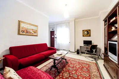 a living room with a red couch and a table at Mons Aureus Resort in Rome
