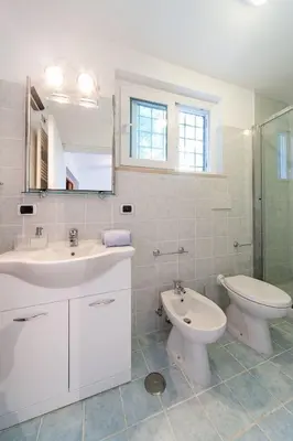 a bathroom with a sink and a toilet and a mirror at Mons Aureus Resort in Rome
