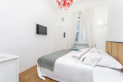 a white bedroom with a bed and a television at Daplace - Matilde Apartment in Rome