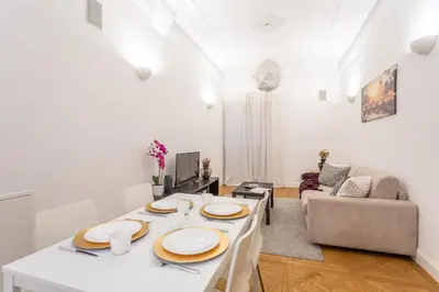 a white living room with a table and a couch at Daplace - Matilde Apartment in Rome