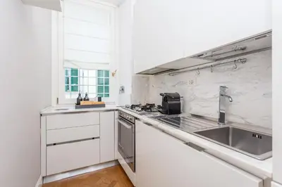a white kitchen with a sink and a stove at Daplace - Matilde Apartment in Rome