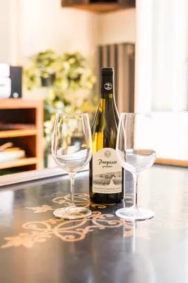 a bottle of wine and two wine glasses on a counter at R.C. Cappellari Charming Campo de Fiori in Rome