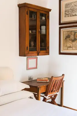 a bedroom with a wooden cabinet and a table at R.C. Cappellari Charming Campo de Fiori in Rome