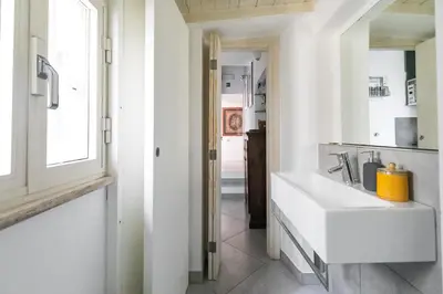 a white bathroom with a sink and a window at R.C. Cappellari Charming Campo de Fiori in Rome