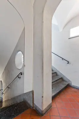a staircase in a building with a circular window at R.C. Cappellari Charming Campo de Fiori in Rome
