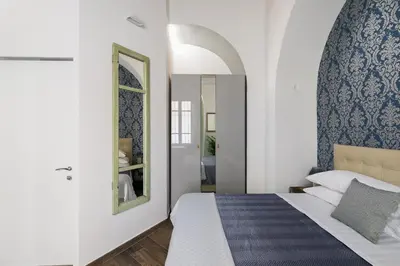 a bedroom with a large bed and a mirror at Horti Sallustiani Roma in Rome