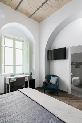 a bedroom with a bed and a desk and a chair at Horti Sallustiani Roma in Rome