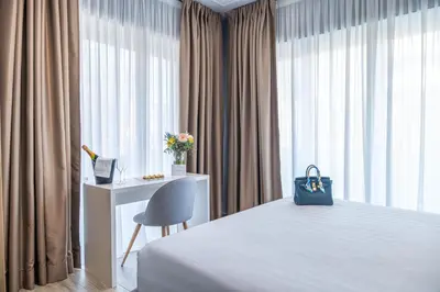 a bedroom with a bed and a desk and a blue bag at Nouvelle Maison Rome Luxury Palace in Rome