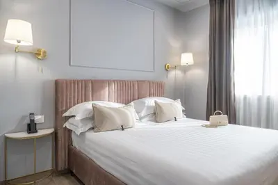 a bedroom with a large bed with white sheets and pillows at Nouvelle Maison Rome Luxury Palace in Rome