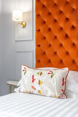 a bed with a orange padded headboard and a pillow at Nouvelle Maison Rome Luxury Palace in Rome