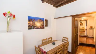 a dining room with a table and a vase with flowers at Rental in Rome Scala Deluxe in Rome