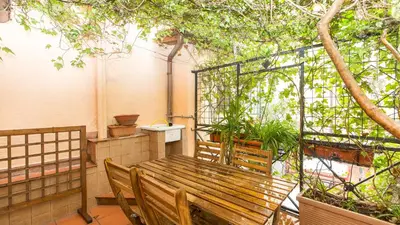 a wooden bench sitting on a balcony with trees at Rental in Rome Scala Deluxe in Rome