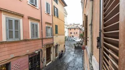 an alley with buildings and a motorcycle on a rainy street at Rental in Rome Scala Deluxe in Rome