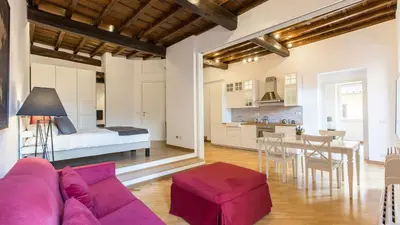 a living room with a purple couch and a kitchen at Rental in Rome Trastevere Atmosphere in Rome