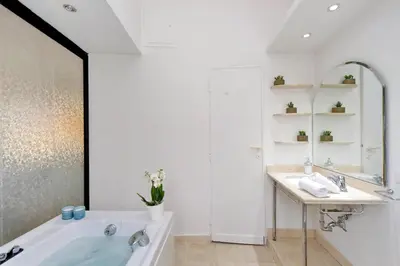 a bathroom with a tub and a sink and a mirror at Merulana Suite S.Peter in Rome