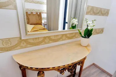 a mirror and a table with flowers on it at Merulana Suite S.Peter in Rome
