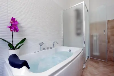 a bathroom with a tub with a purple flower in it at Merulana Suite S.Peter in Rome
