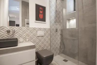 a bathroom with a toilet and a sink and a shower at 1 bdr apartments Ambio Suites Luxury Trastevere in Rome