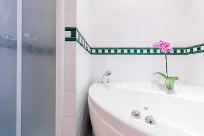 a bathroom with a sink and a vase with a flower in it at Dream House Vaticano in Rome
