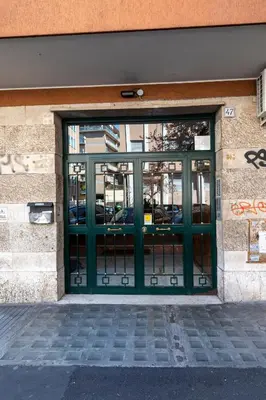a green door to a building with cars in it at Rizzo St. Peter apartment in Rome