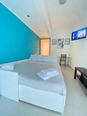 a white room with a bed and a tv at Rizzo St. Peter apartment in Rome