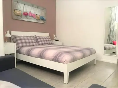 a bedroom with a white bed with a purple blanket at CRIS - close to VATICAN - Centre&StadiumArea in Rome