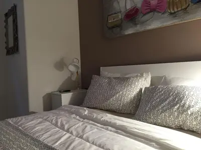a bed with white sheets and pillows in a bedroom at CRIS - close to VATICAN - Centre&StadiumArea in Rome